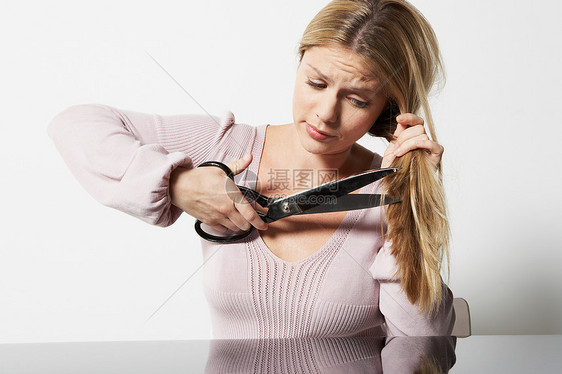 女人用剪刀剪自己的头发图片