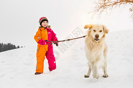 女孩在雪地里遛狗图片