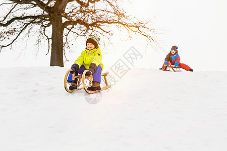 两个男孩在雪地里玩雪橇图片