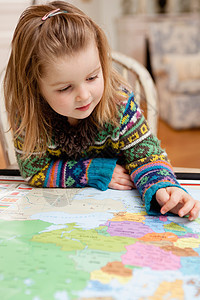小女孩用手指探索地图图片