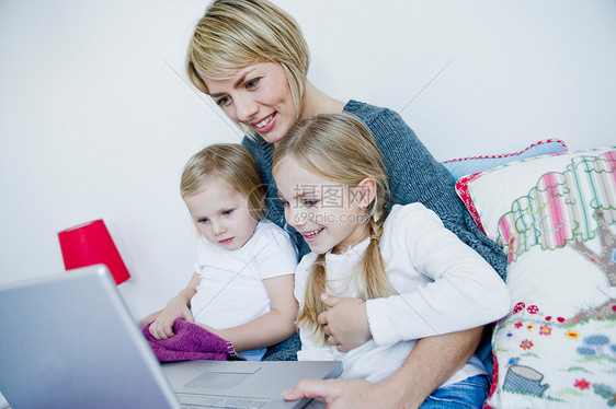 妈妈和两个女孩看着笔记本电脑图片