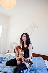 在床上弹吉他的女人图片