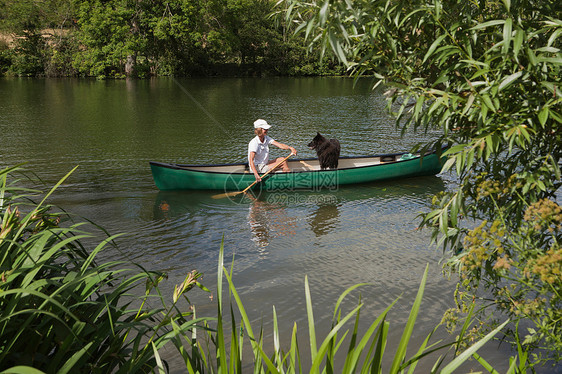 坐独木舟带狗的女人图片