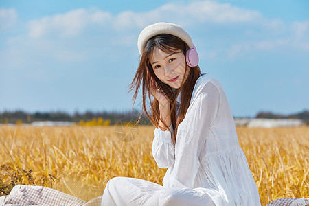 雨水稻田年轻女生户外听音乐背景