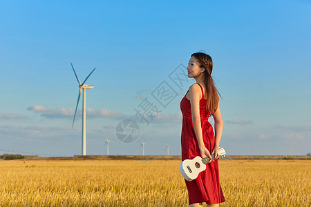 年轻美女手拿尤克里里背影图片