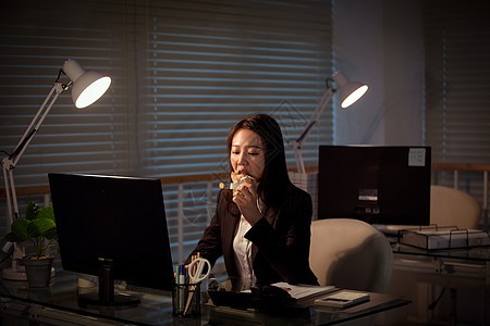 吃工作餐职场女性深夜加班吃三明治背景