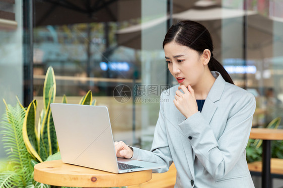 商务女性在咖啡厅用笔记本电脑办公图片