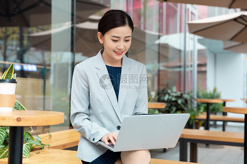 商务女性在咖啡厅用笔记本电脑办公图片