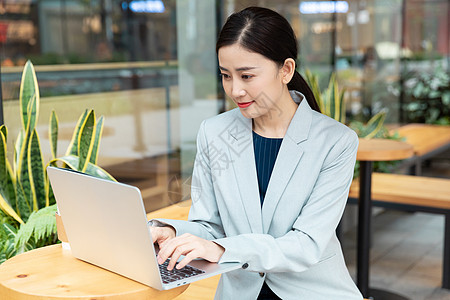 商务女性在咖啡厅用笔记本电脑办公图片