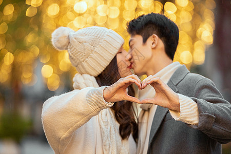 情侣接吻冬季情侣光斑下接吻比爱心背景