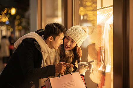 购物分享冬季情侣购物橱窗前挑选衣服背景