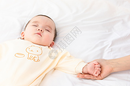 妈妈用手托着睡觉宝宝的手高清图片