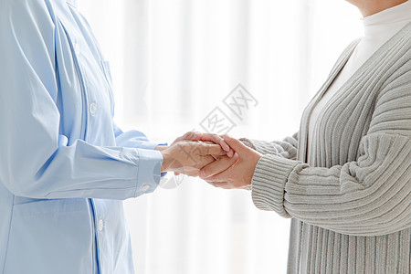 家庭护士和老人握手背景图片