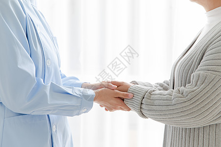家庭护士和老人握手背景图片