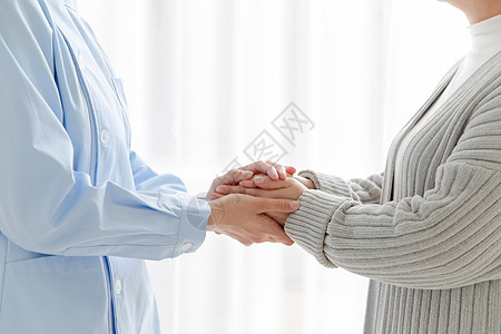 护士关怀家庭护士和老人握手背景