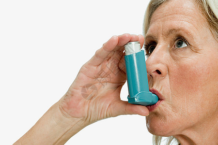 使用哮喘吸入器的妇女图片