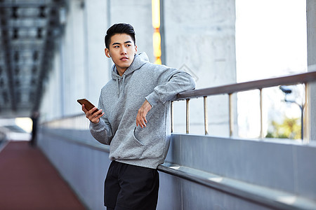 年轻运动男生使用蓝牙耳机通电话背景图片