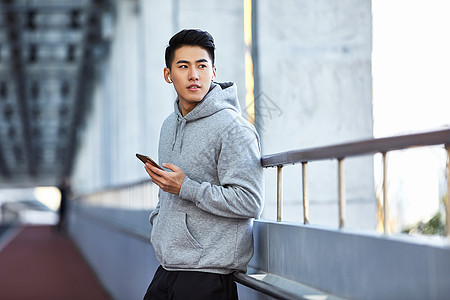 手机运动年轻运动男生使用蓝牙耳机通电话背景