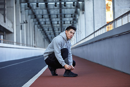 运动男青年系鞋带背景图片