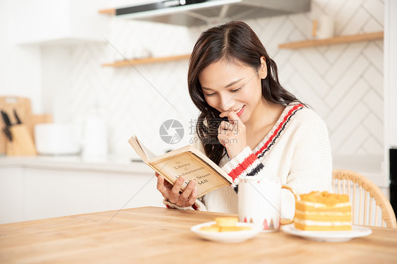冬季青年女性居家看书吃蛋糕喝咖啡图片