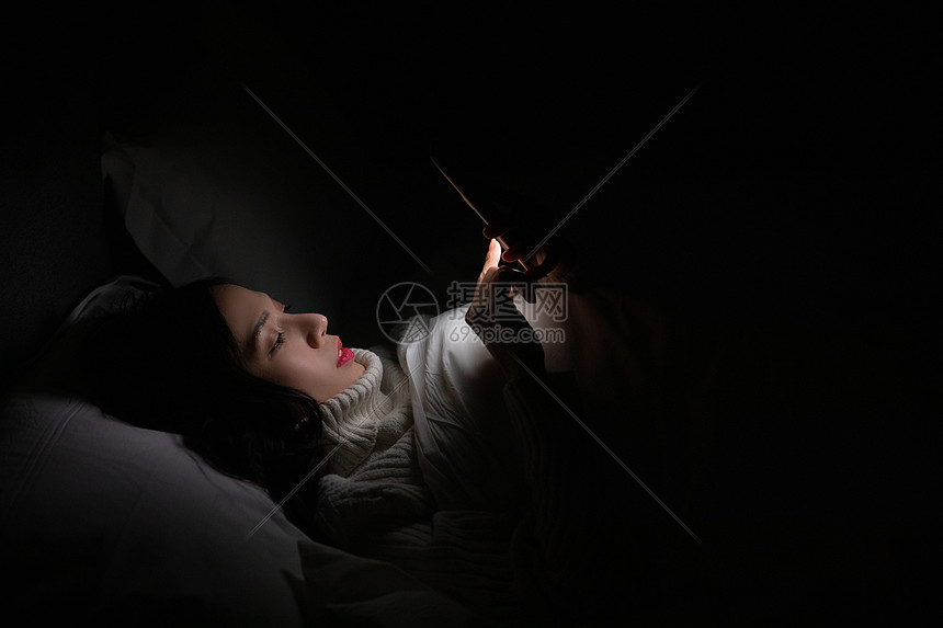 青年女性夜晚熬夜玩手机图片