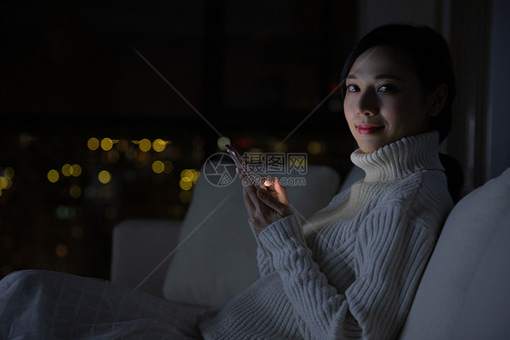 冬季青年女性夜晚玩手机图片