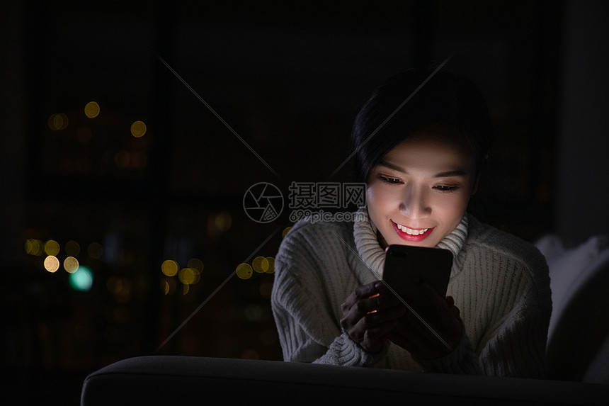冬季青年女性夜晚玩手机图片