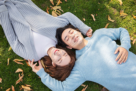 秋天情侣躺在草地上背景图片