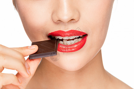 女性吃巧克力嘴部特写背景图片