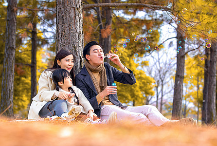 一家三口在公园吹泡泡图片素材