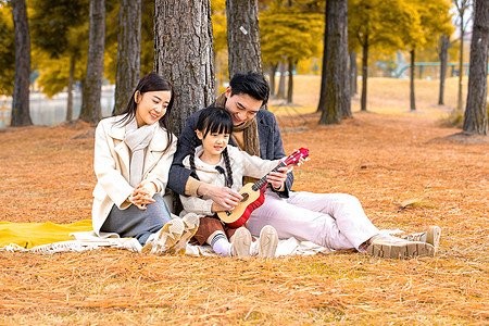 女孩弹尤克里里年轻爸妈陪女儿弹尤克里里背景