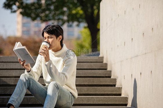 坐在楼梯上看书的青年男性图片