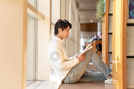 图书馆席地而坐看书的男性图片