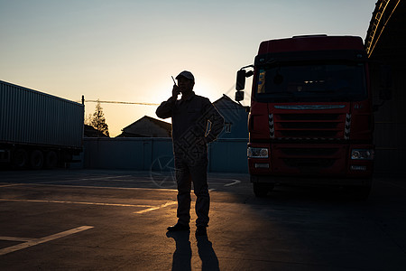 货车司机手拿对讲机逆光剪影形象图片素材
