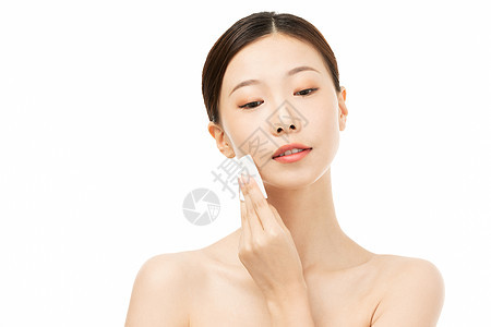 女性使用化妆棉擦拭面部 背景图片