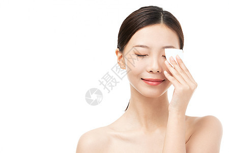 女性使用化妆棉擦拭面部 背景图片
