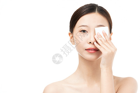 女性擦拭面部女性使用化妆棉擦拭面部背景