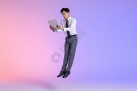 商务男性拿平板电脑跳跃图片