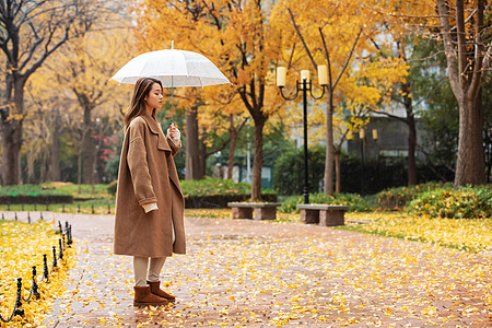 下雨天的人物秋季雨天美女撑伞公园散步背景