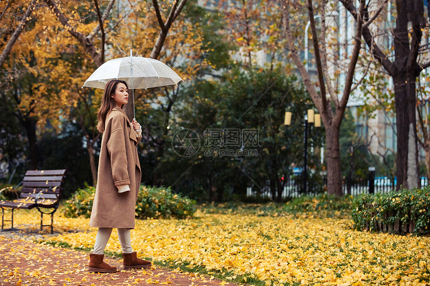 秋季雨天美女撑伞公园散步图片