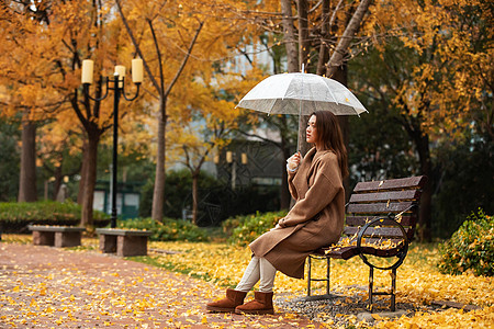 雨天晾衣服秋季雨天美女公园撑伞背景