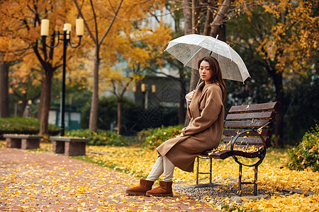 秋季雨天美女公园撑伞图片