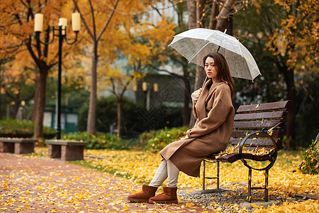 秋季雨天美女公园撑伞图片