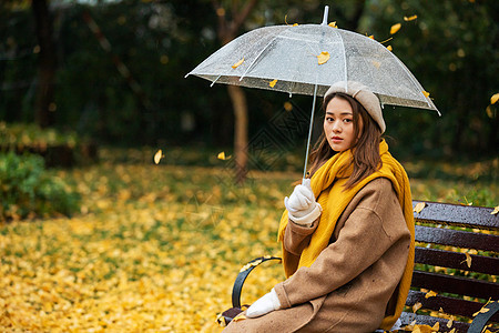 秋季雨天文艺美女公园撑伞背景图片