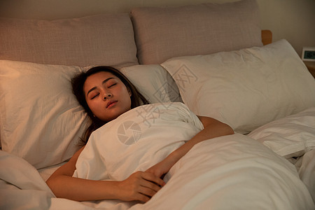 夜晚女性床上睡觉背景图片