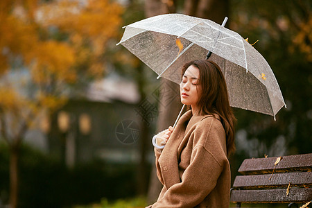秋季雨天美女银杏落叶撑伞图片