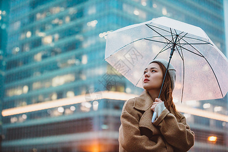 雨天撑伞人冬季户外孤单女性撑伞背景