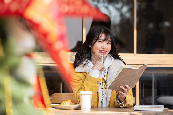 坐在咖啡厅看书的女大学生  图片