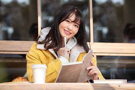 在咖啡馆写作业的女大学生图片