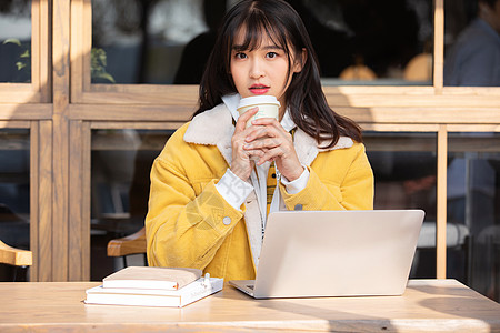 坐在咖啡馆喝咖啡的女孩图片